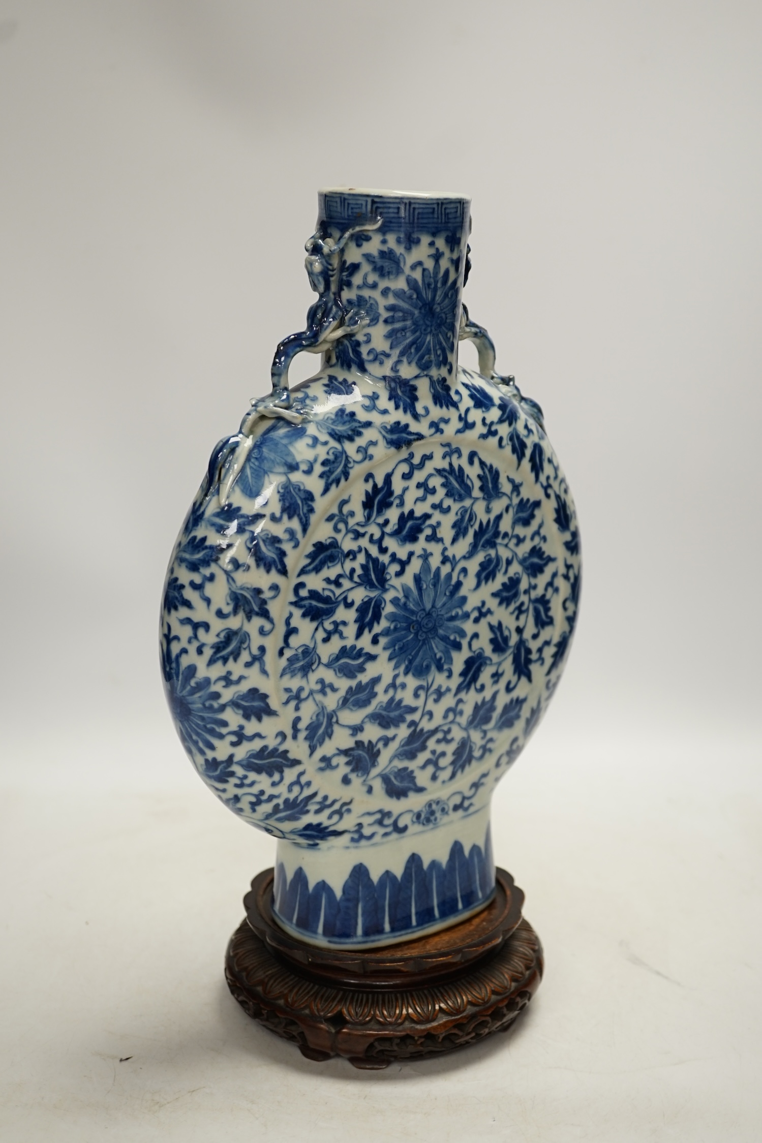 A 19th century Chinese blue and white moon flask on a hardwood stand, overall 35cm high. Condition - typical minor glaze imperfections